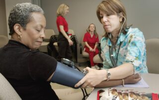 A women gets her blood pressure taken by a nurse.