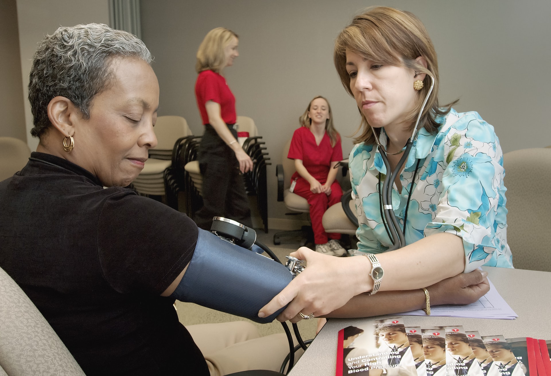 A women gets her blood pressure taken by a nurse.
